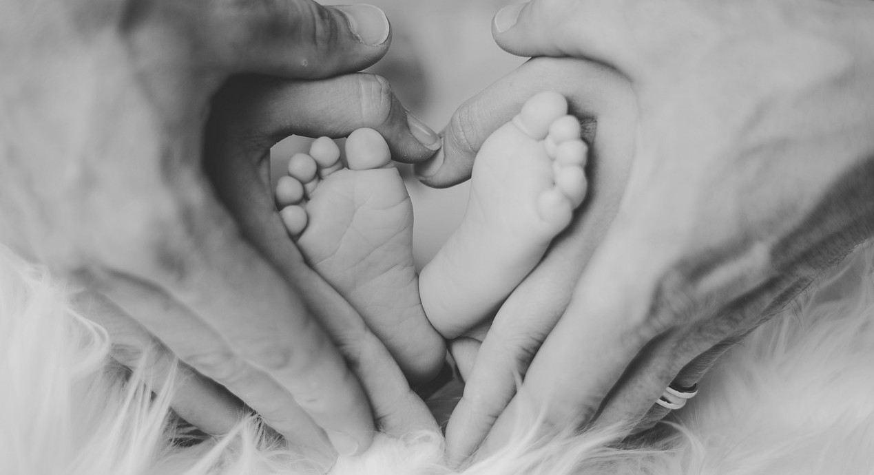 baby feet and adult hands heart shaped