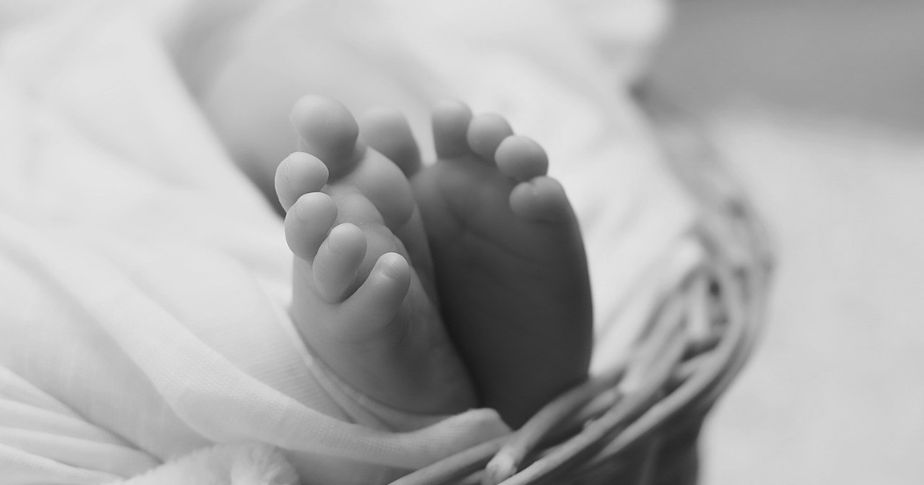two newborn feet at end of crib