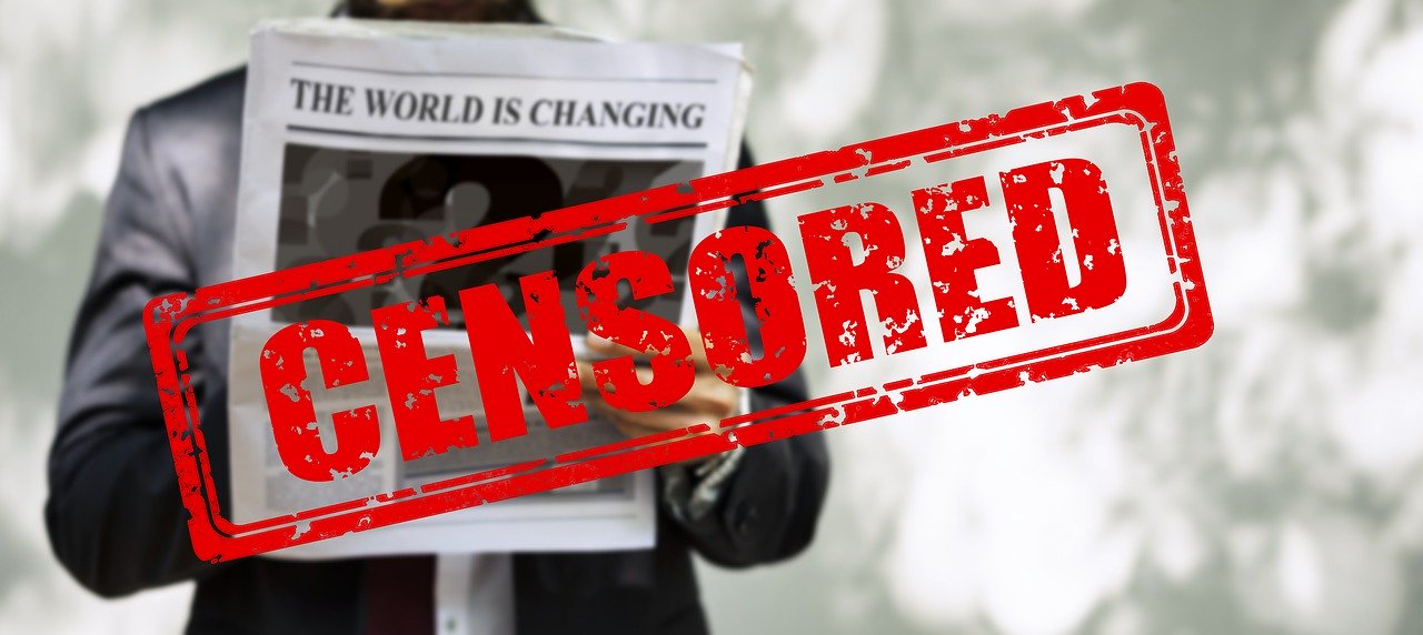 reader of newspaper with censored written across