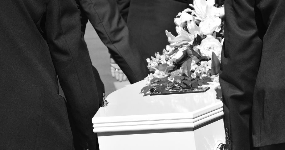 casket, pall bearers and flowers