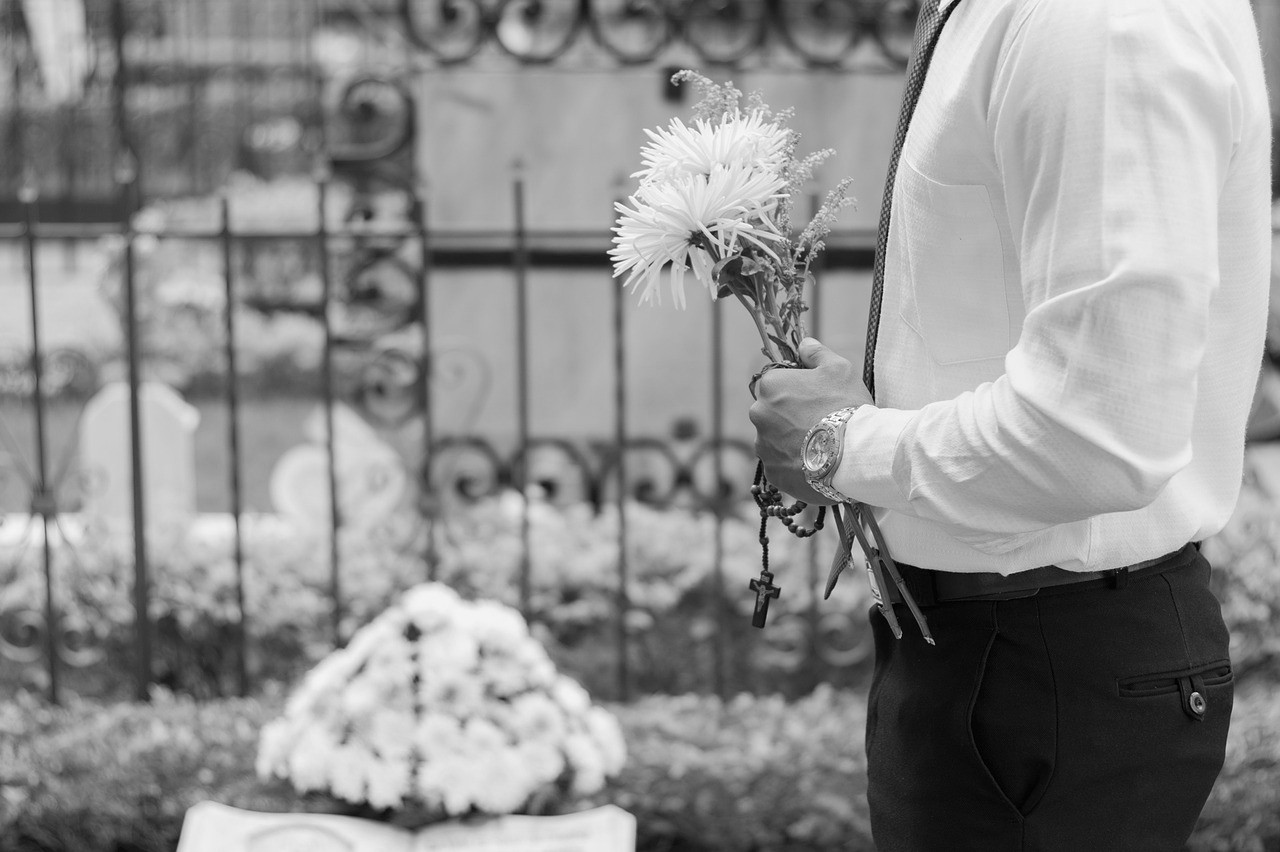 man-at-funeral-with-flower