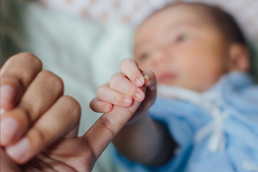 baby hand holding adult hand