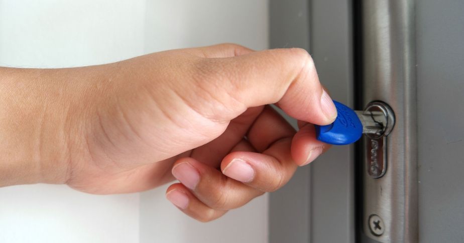 hand unlocking a door with key