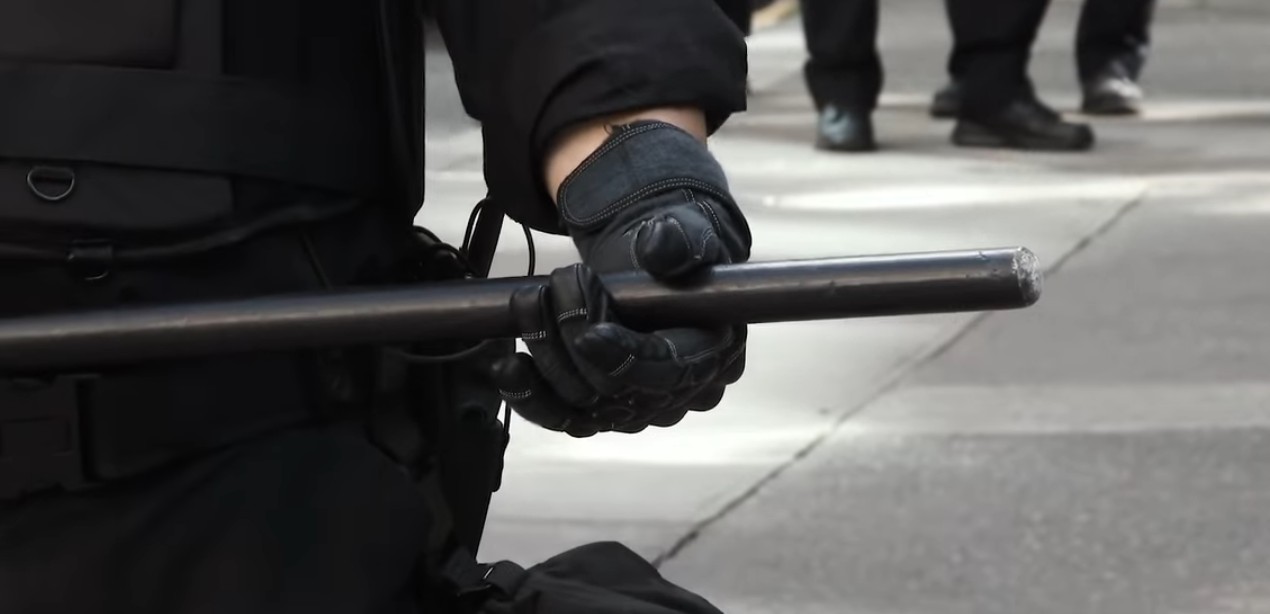 black clad person with baton